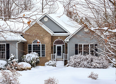A house in a winter setting with replacement windows and a new door.